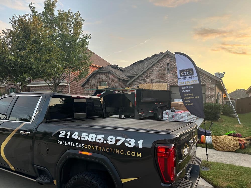 Relentless Contracting truck at a residential roofing project with sunset backdrop.