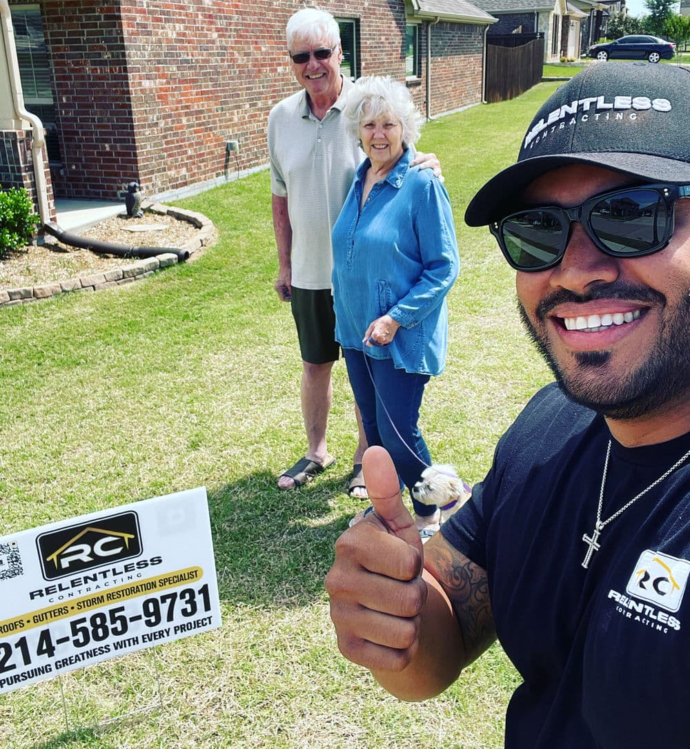 Roofing and storm restoration specialists with satisfied homeowners and their dog.