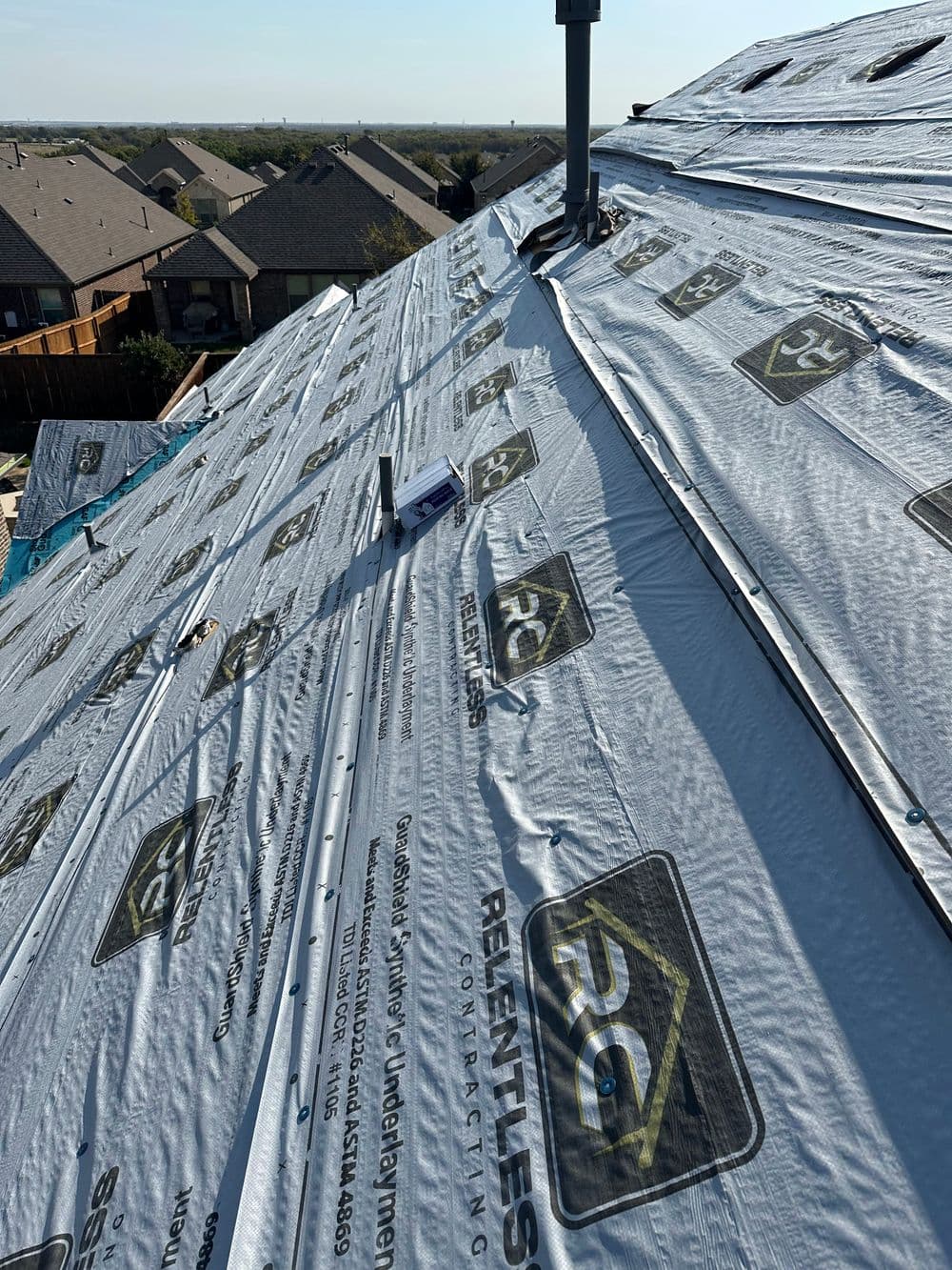 Newly installed roofing underlayment covering a sloped residential roof.
