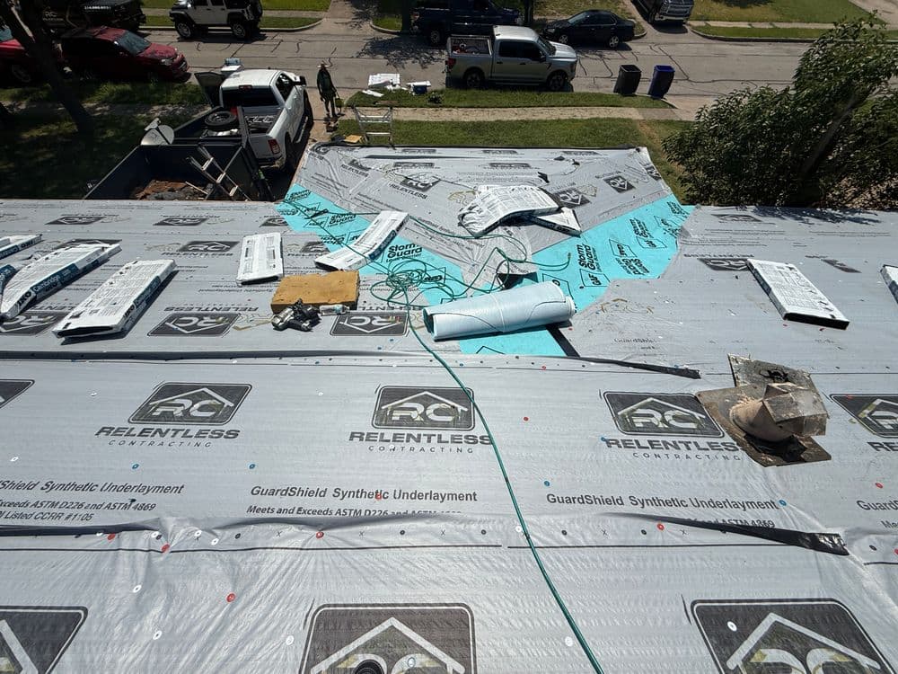 Roofing materials and installation in progress, featuring underlayment and tools on a residential roof.
