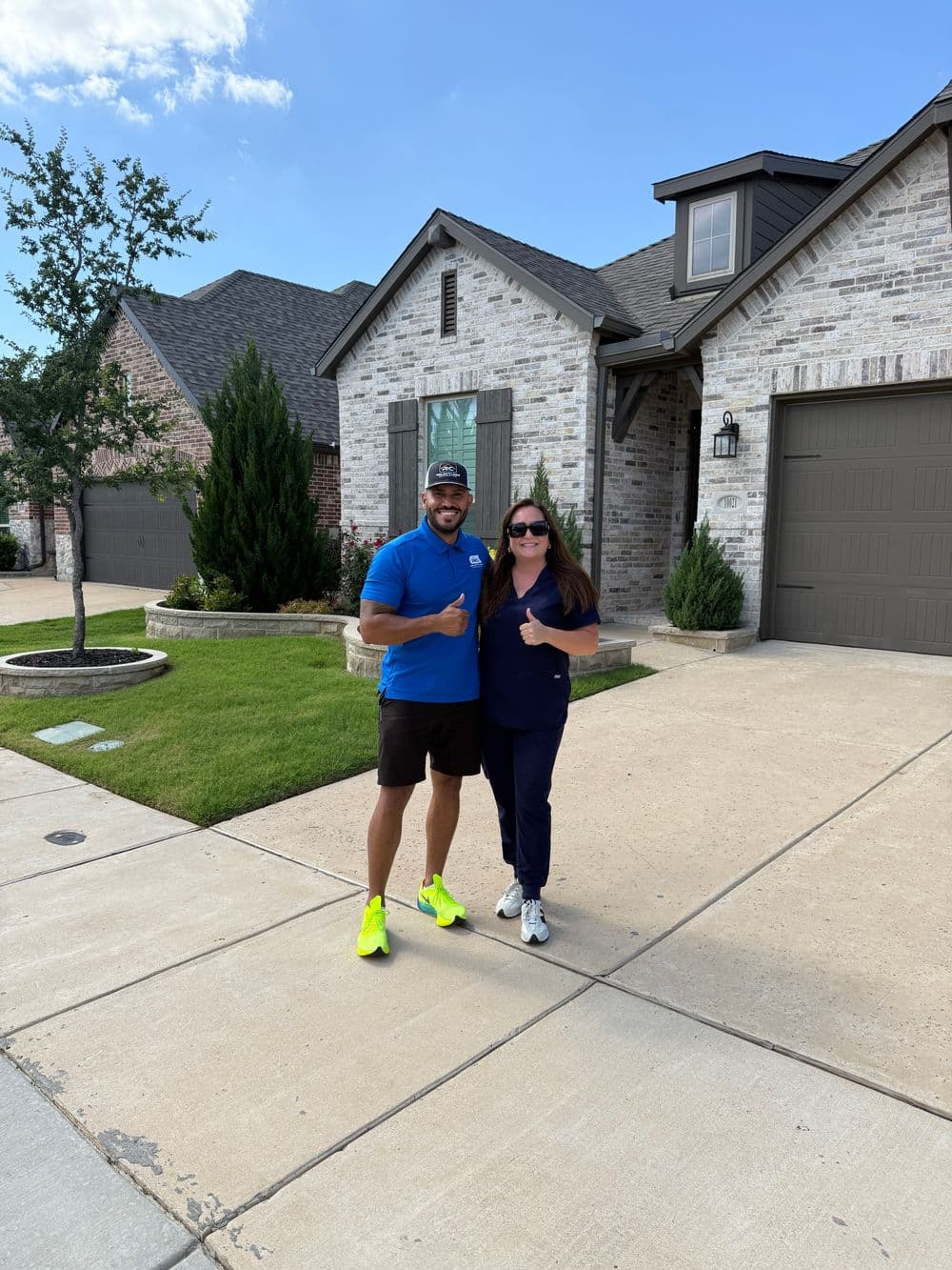 Happy homeowners standing outside their new house, smiling and celebrating together.